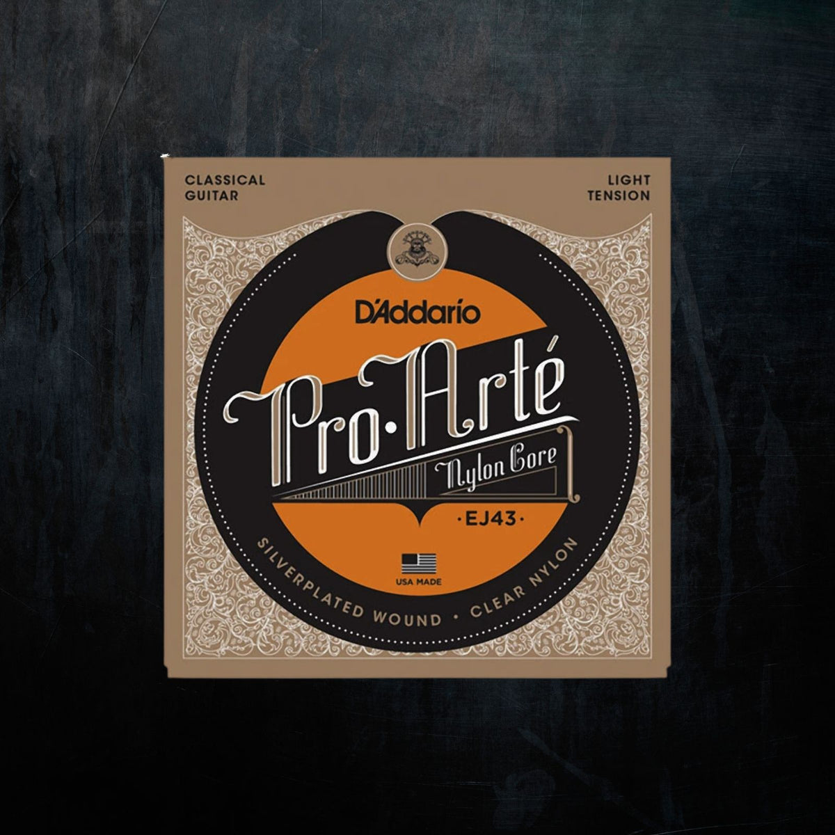 D'Addario Pro Arté Classical Guitar Nylon Core EJ43 string package, featuring a circular black and orange label on a beige patterned background, set against a dark textured backdrop.